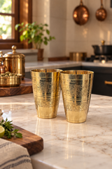 Far angle 50mm lifestyle photo of two engraved brass tumblers on kitchen counter