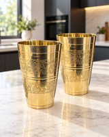 Set of two handcrafted engraved brass tumblers on a marble countertop
