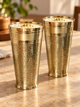 Pair of engraved brass tumblers filled with lassi