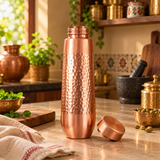 Hammered copper water bottle with lid open in a traditional kitchen