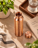 Top view of open Heritage Floral Engraved Copper Water Bottle with lid beside it