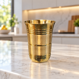 Front-facing royal ribbed brass tumbler centered in a modern kitchen
