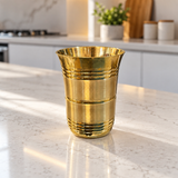 Single royal ribbed brass tumbler on a marble countertop