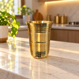 Single royal ribbed brass tumbler in a sunlit kitchen